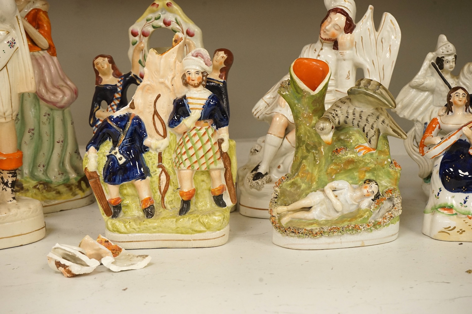 A collection of Staffordshire figures, mostly flatback to include a pocket watch holder, largest 37cm high